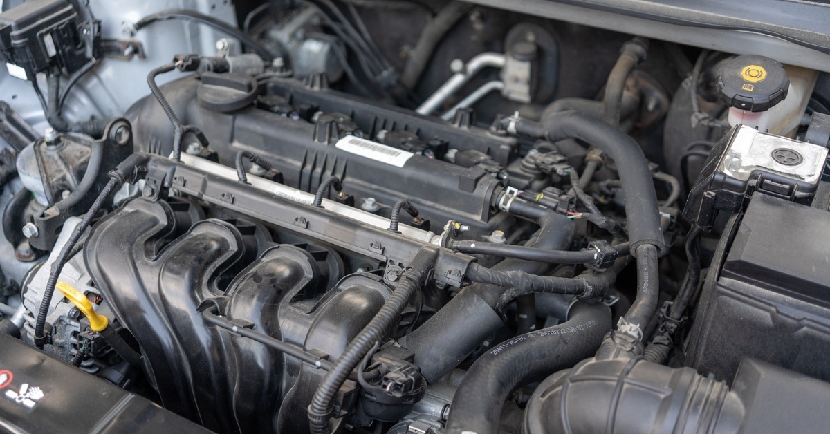 A wide view of a vehicle's engine bay and its various components, which include the intake manifold and multiple hoses. A wide view of a vehicle's engine bay and its various components, which include the intake manifold and multiple hoses.